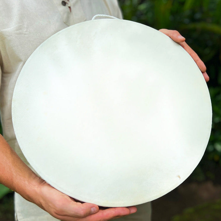 Musician tilting Ocean Drum to create soothing wave sounds